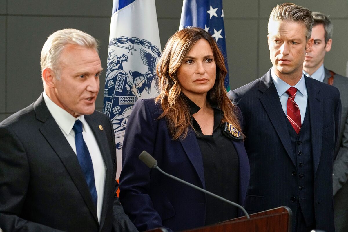 Terry Serpico, left, speaks at a podium next to Mariska Hargitay and Peter Scanavino in "Law & Order: SVU."