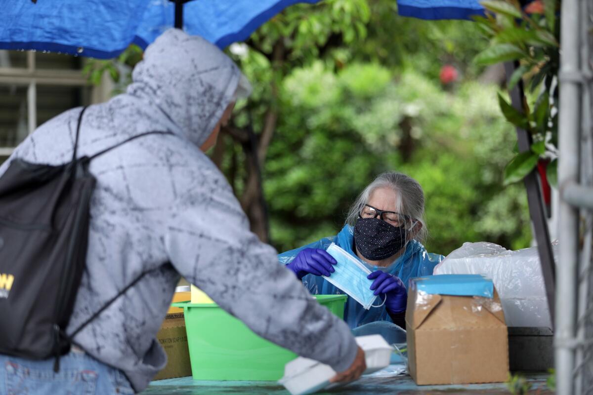 Volunteer Ann Boden hands out masks and toiletries to people on skid row. 