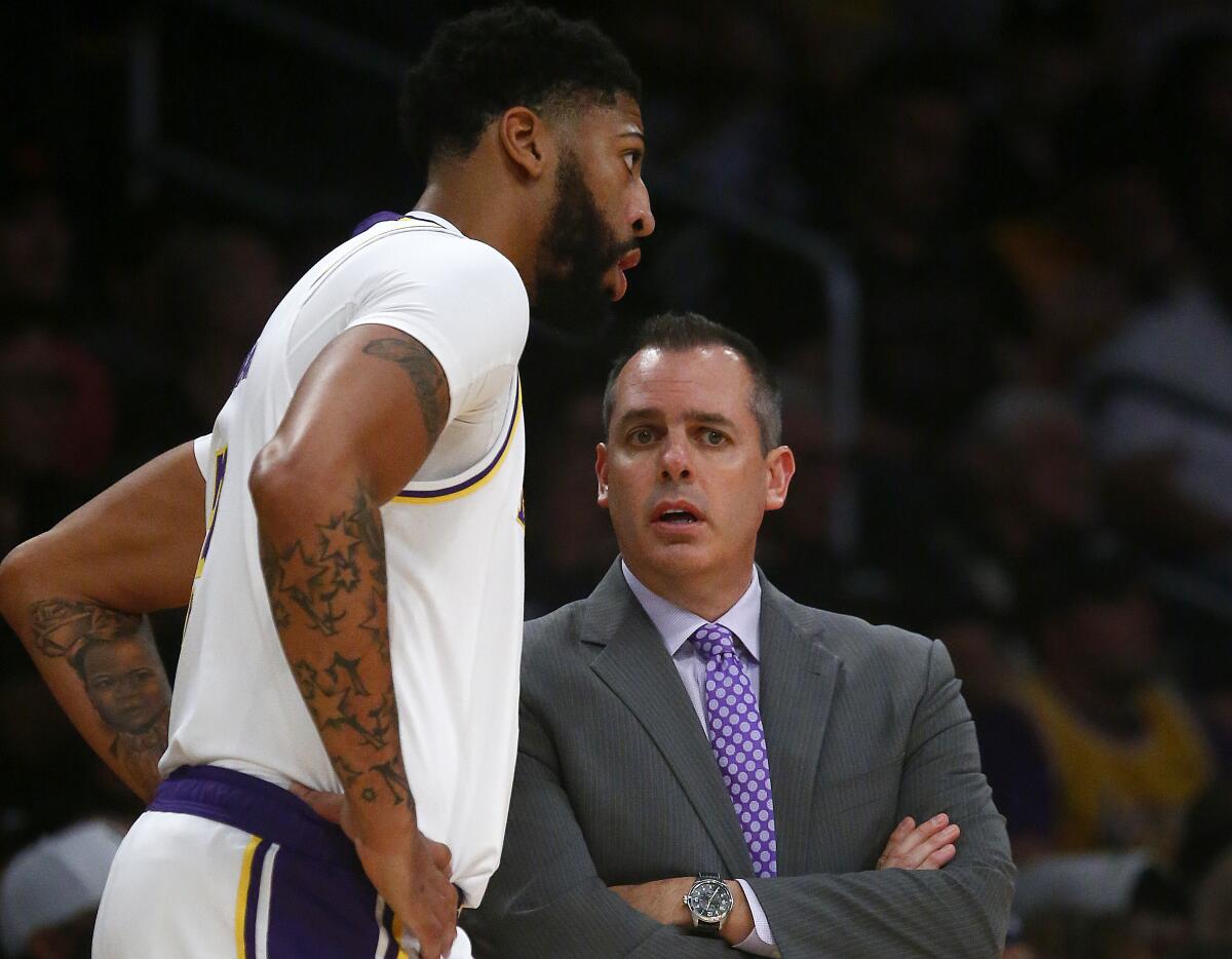 Lakers forward Anthony Davis chats with coach Frank Vogel during the third quarter against the Raptors  at Staples Center.