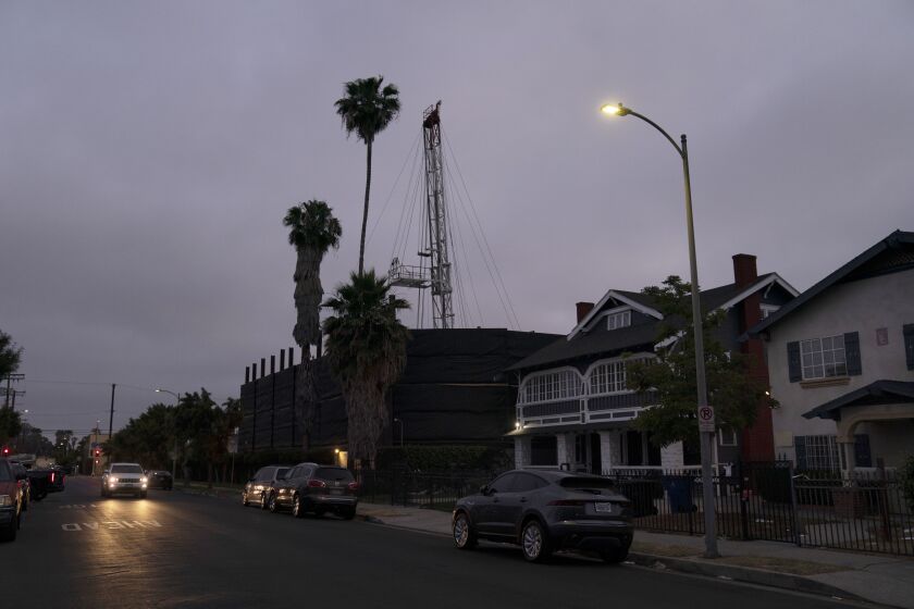 FILE - A vehicle drives past the Jefferson oil drill site located in the residential area in Los Angeles, June 2, 2021. The Los Angeles City Council voted on Friday, Dec. 2, 2022, unanimously to ban new oil and gas drill sites and phase out existing ones over the next 20 years on Friday. (AP Photo/Jae C. Hong, File)