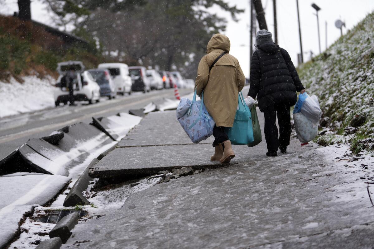 A snowy street in Wajima, Japan, is buckled after an earthquake.
