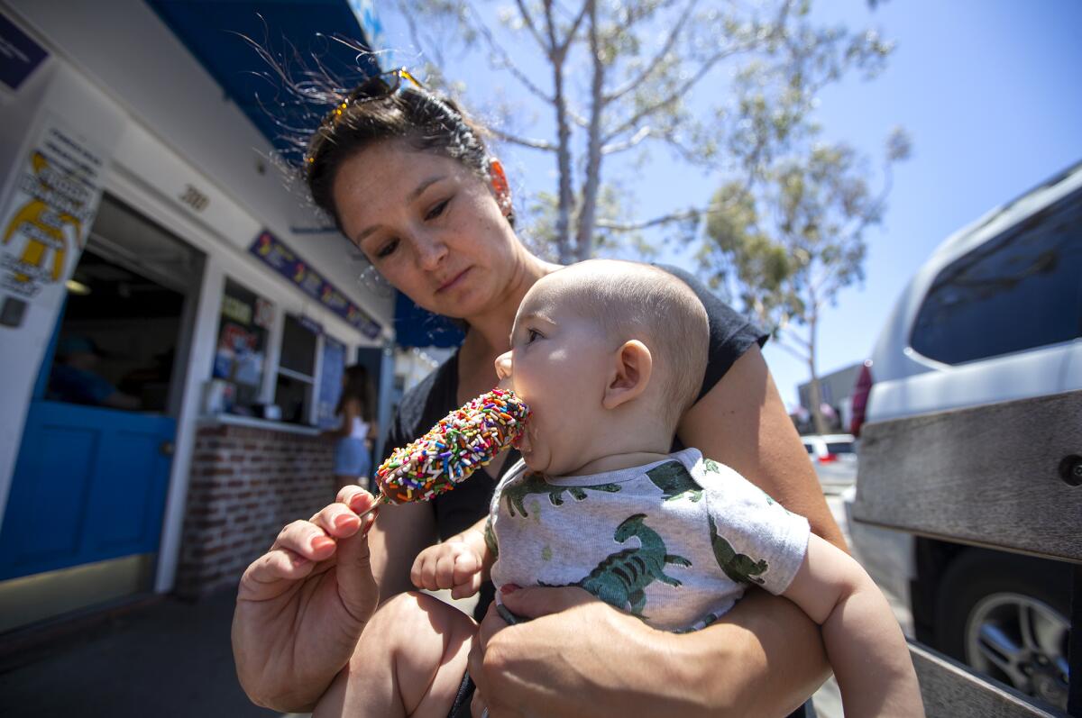 Katie Contois gives her son, Mason, 6 months, a bite of an ice cream bar.