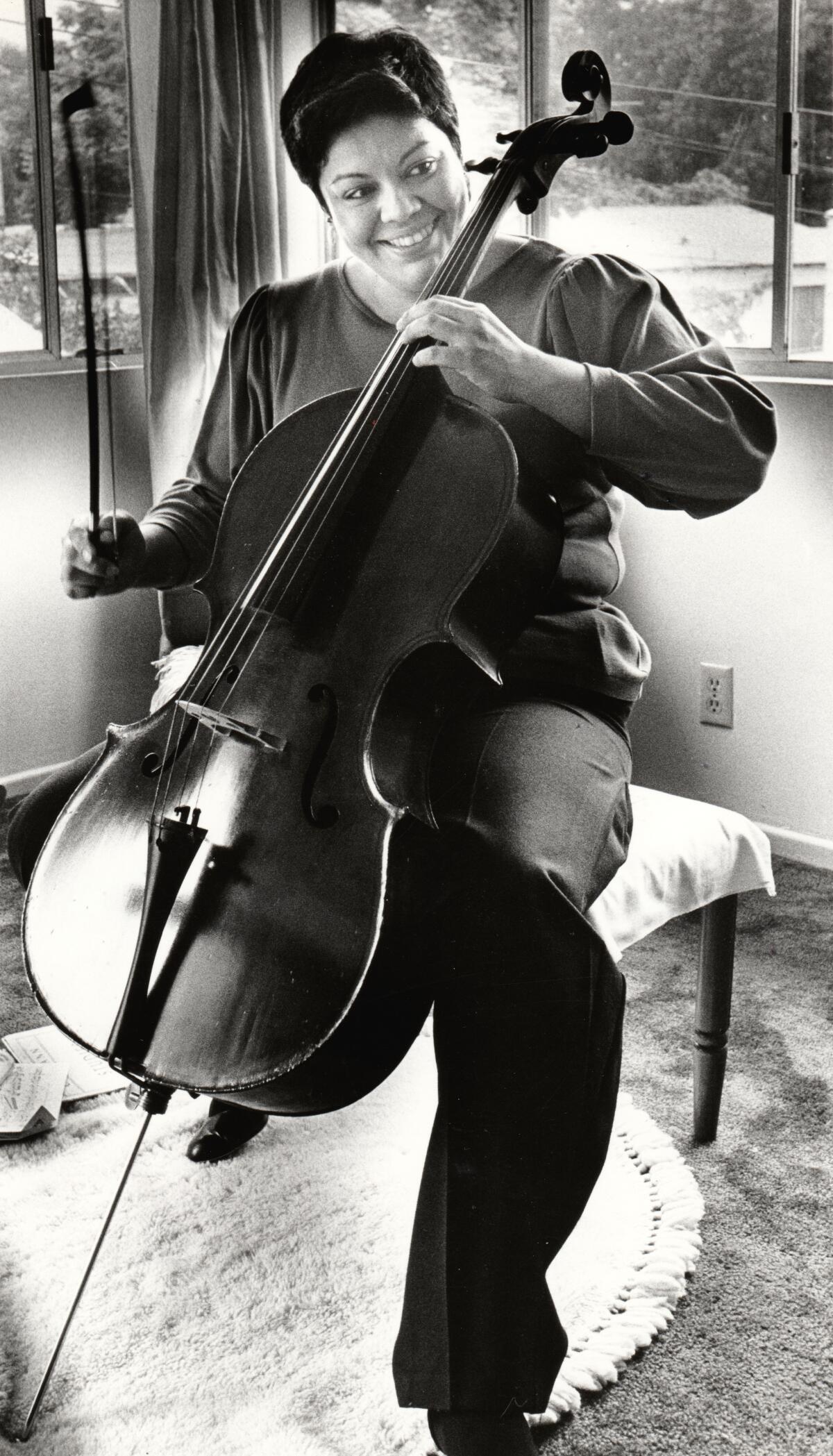 Maria Elena Gaitan, poet, playwright and classical musician, practices her cello in her Glendale apartment.