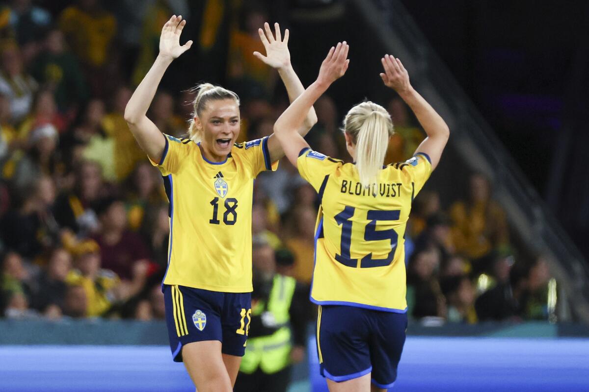 Sweden's Fridolina Rolfo and teammate Rebecka Blomqvist high-five.