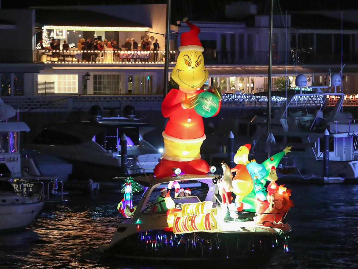 "Merry Grinchmas" makes a U-turn at the Balboa Island Bridge to the delight of a party gathered Wednesday at Newport Harbor.
