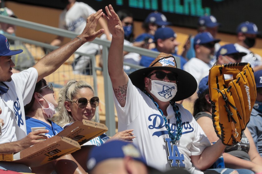A fan with an extra large glove is congratulated after catching a ball in the left field pavilion at Dodger Stadium. 