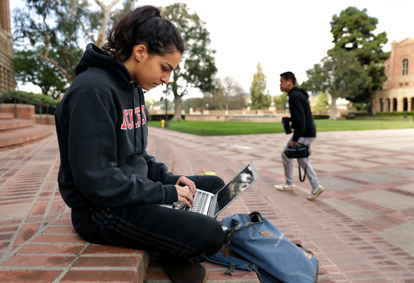 Student Shaya Naimi, 19, hangs out on the steps of Powell Library at UCLA, where most students have left campus and classes have moved to online only.