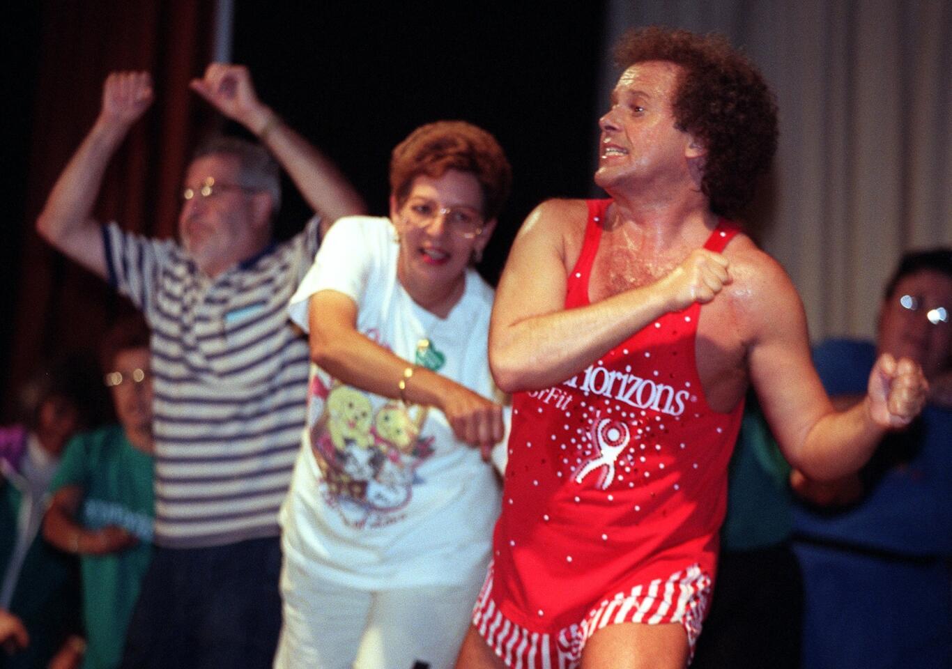 Fitness guru Richard Simmons leads a group of seniors in an exercise routine at Long Beach Memorial Medical Center on June 16, 1998 at the Secure Horizons Wellness Festival. This is the 70-to-80-year-old group exercising with him.