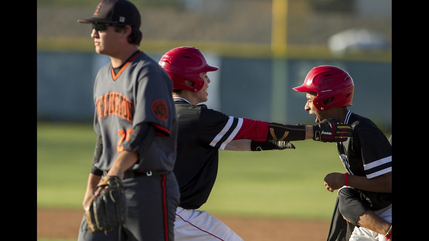 Huntington Beach's Justin Cianca, left reacts after Los Alamitos's Chris Rubottom, center, celebrates with AJ Mayeda on a walk off win in a Sunset League game on Wednesday, April 5.