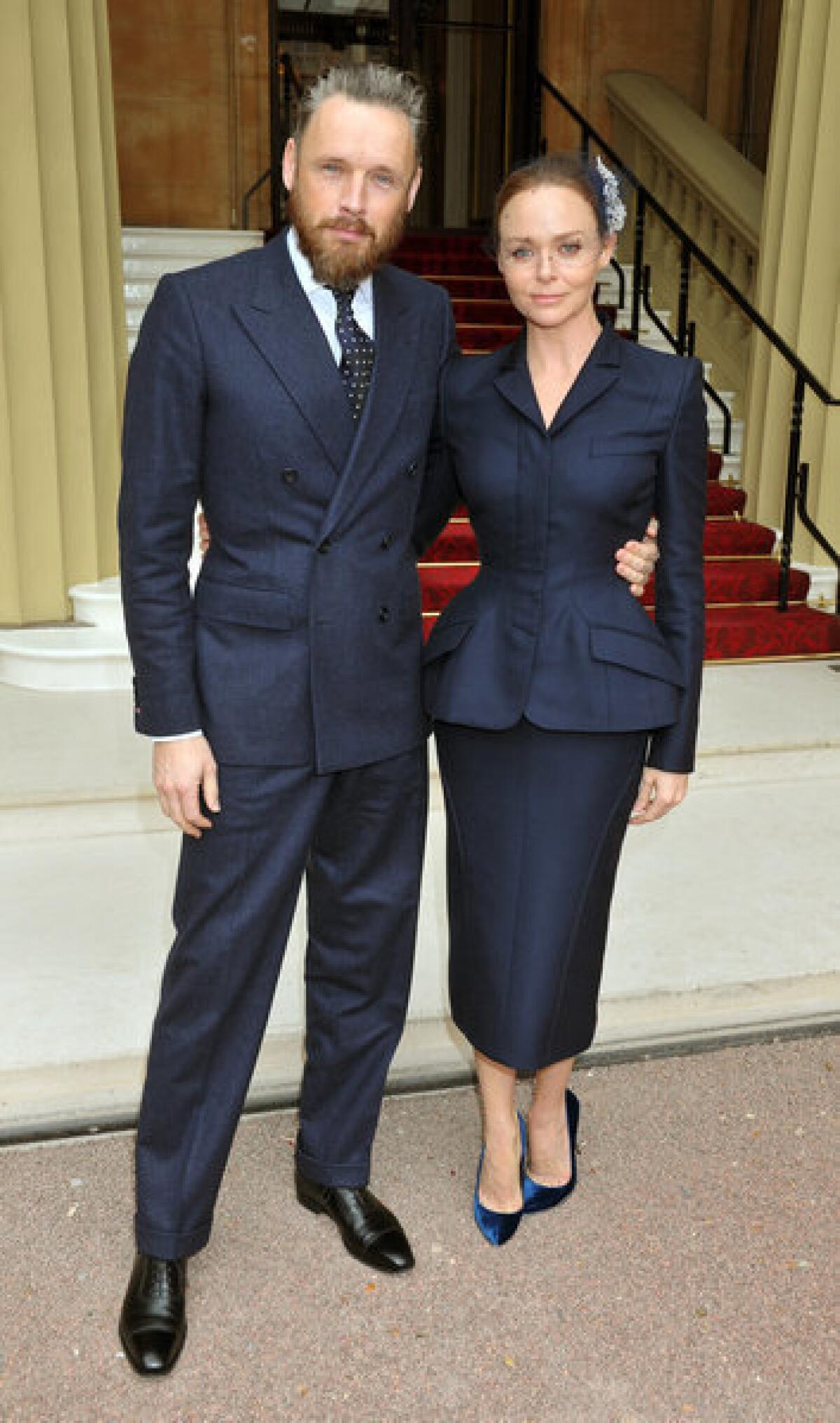 Stella McCartney arrives with husband Alasdhair Willis for a ceremony at Buckingham Palace, where she was made an officer of the Order of the British Empire.