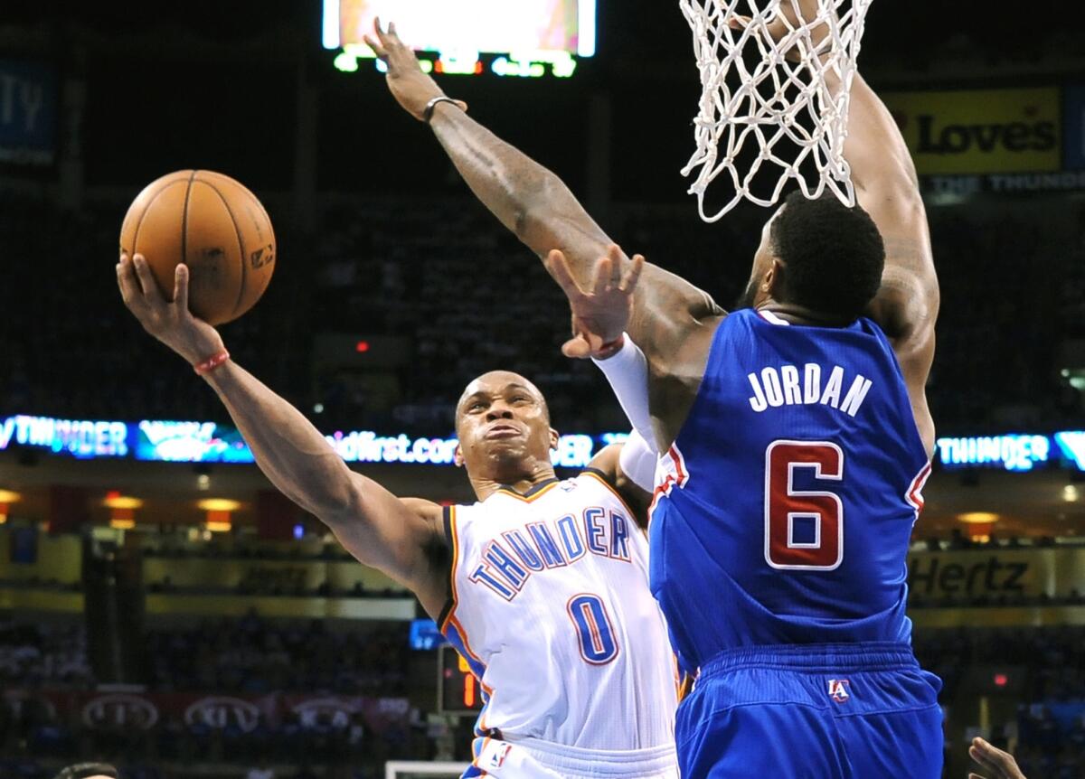 Thunder point guard Russell Westbrook has his driving layup challenged at the basket by Clippers center DeAndre Jordan.