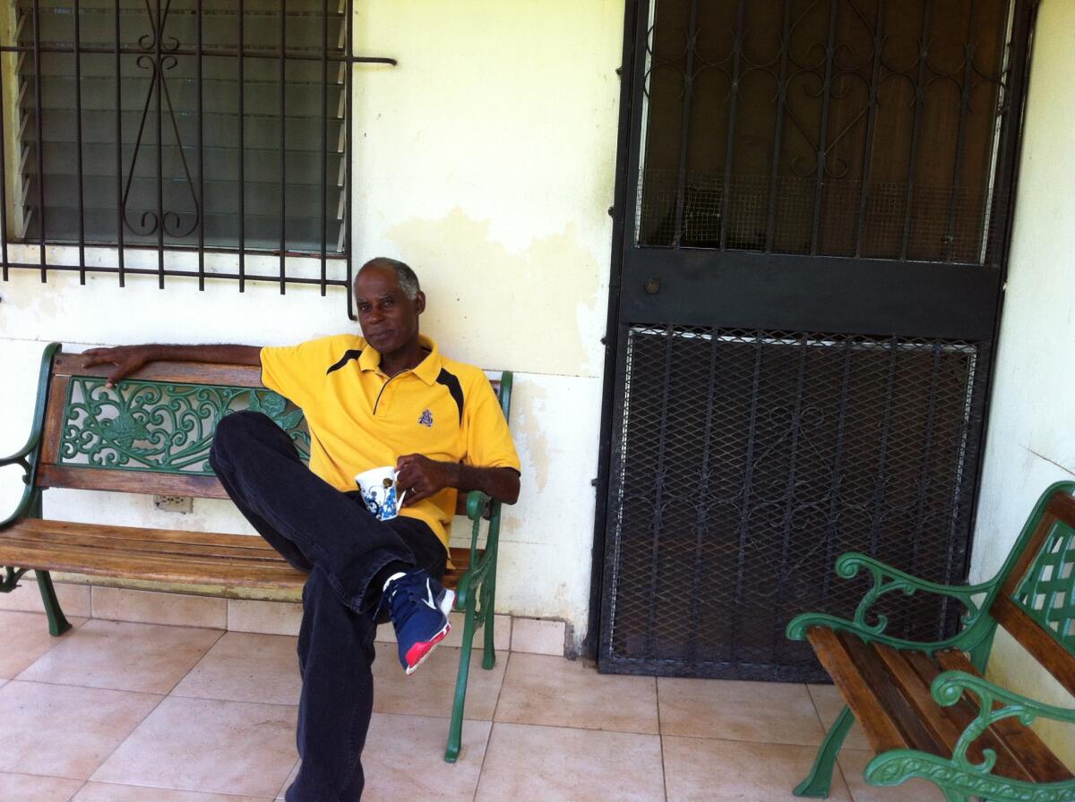 Gary Evans sits on a bench on a porch.