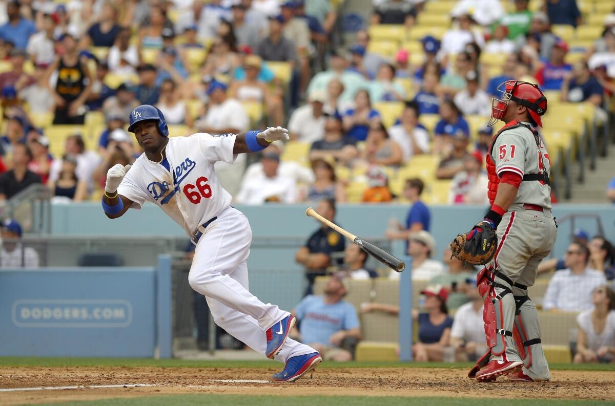 Yasiel Puig hits a triple as Philadelphia Phillies catcher Carlos Ruiz looks on during the fifth inning of the Dodgers' 6-1 victory.