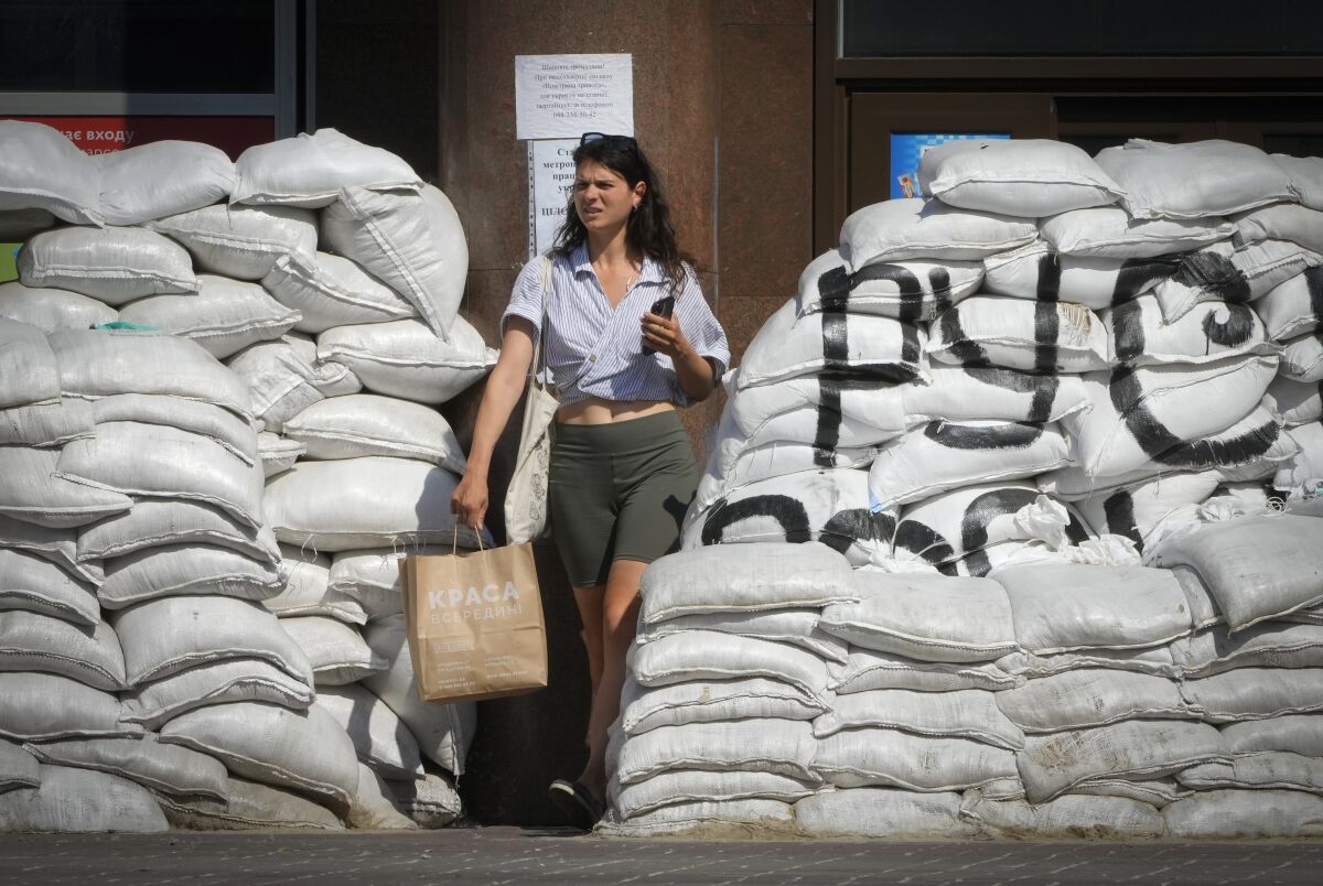 Woman walking amid piled-up sandbags