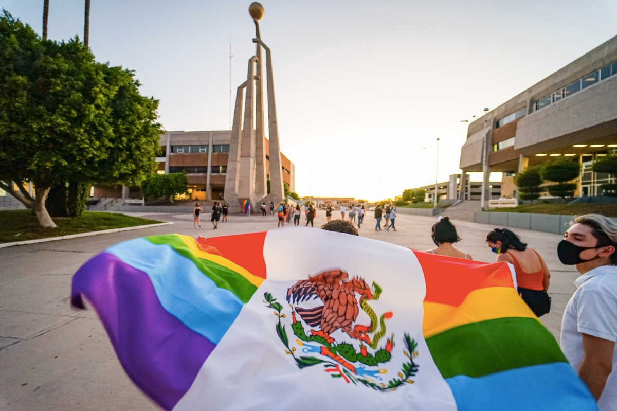 Alejandro Sánchez Flores, co-founder of www.LGBCT.com, carries a pride rainbow Mexican flag.