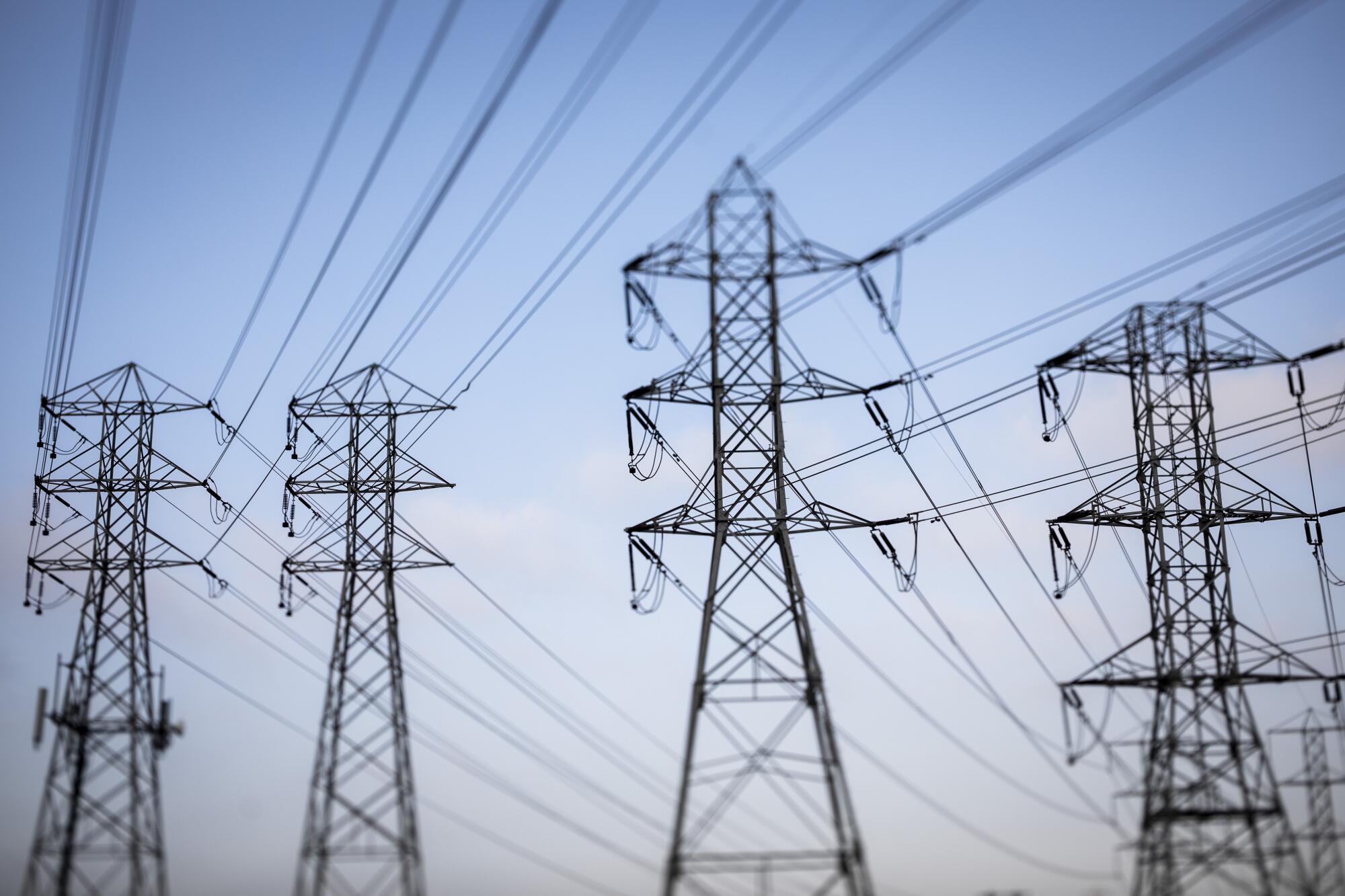 Overhead electric lines are pictured against a blue sky. 