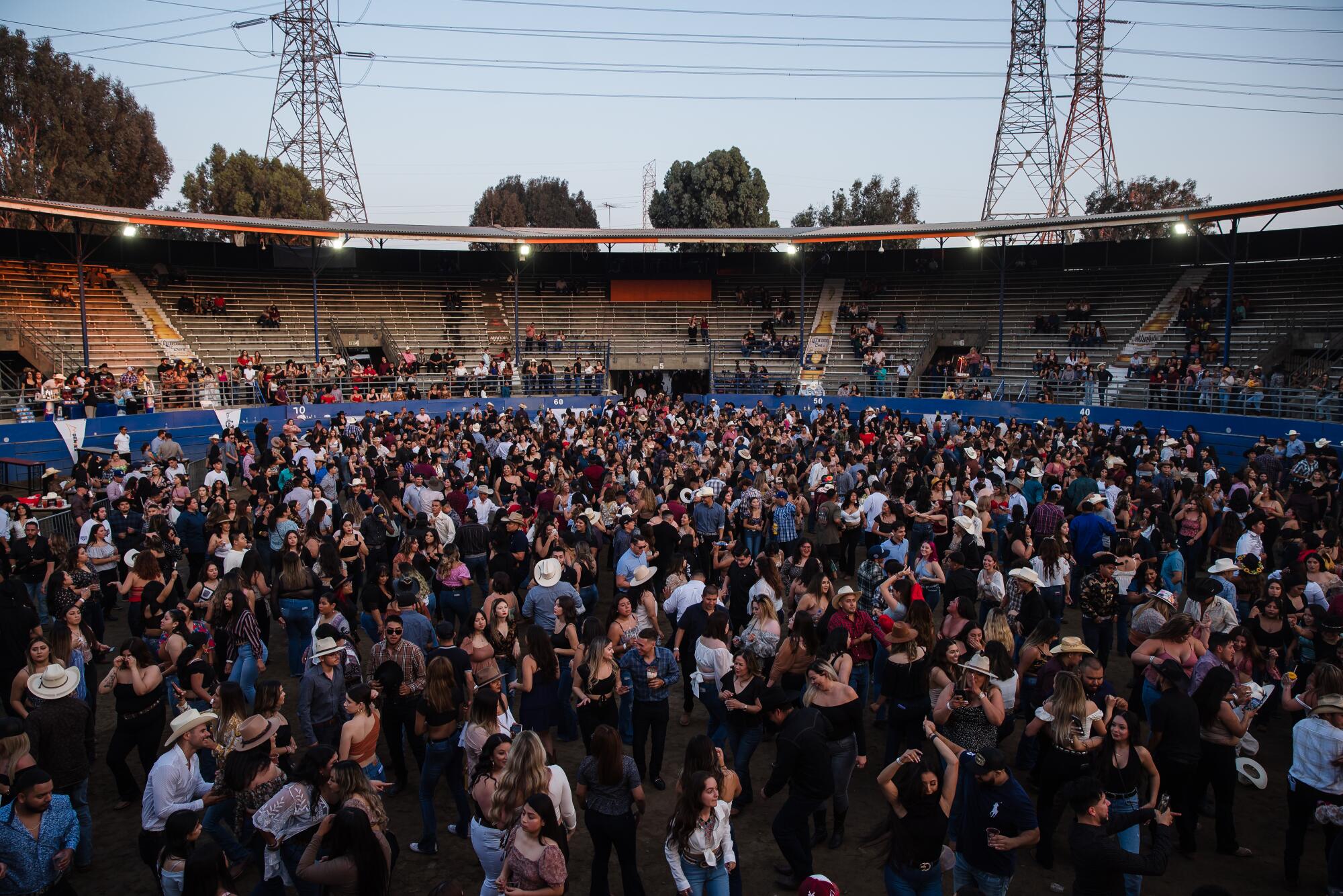 La gente baila en el Pico Rivera Sports Arena después del concurso de charrería.