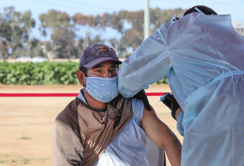 Farm worker Federico Robles gets a Moderna COVID-19 vaccine from Cal Fire