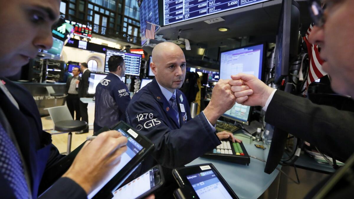 Specialist Mario Picone, center, works with traders Nov. 9 at his post on the floor of the New York Stock Exchange.