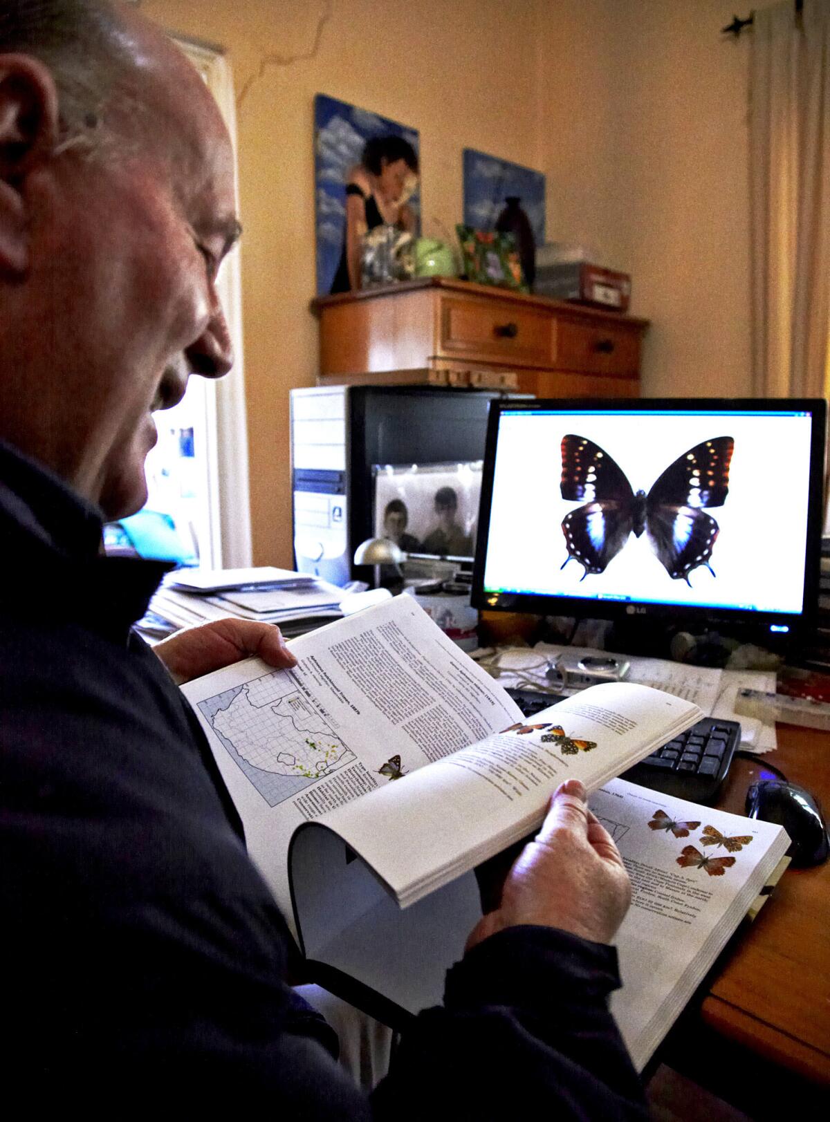 Mark Williams pages through a butterfly book he co-wrote. "I'm being called the Butterfly Whisperer," Williams says. "I'd love to go out with that title. Mark Williams, the Butterfly Whisperer."