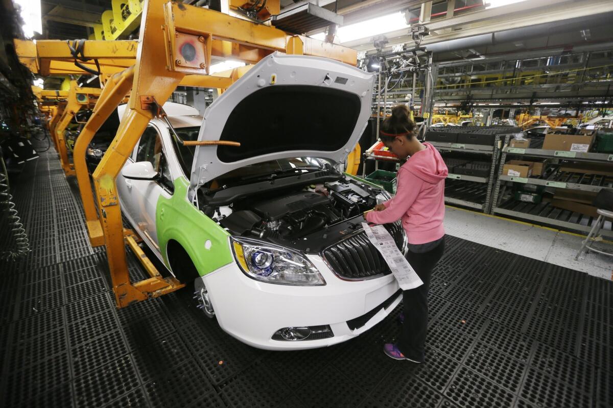Final trim is installed on a Buick Verano at a General Motors factory in Michigan.