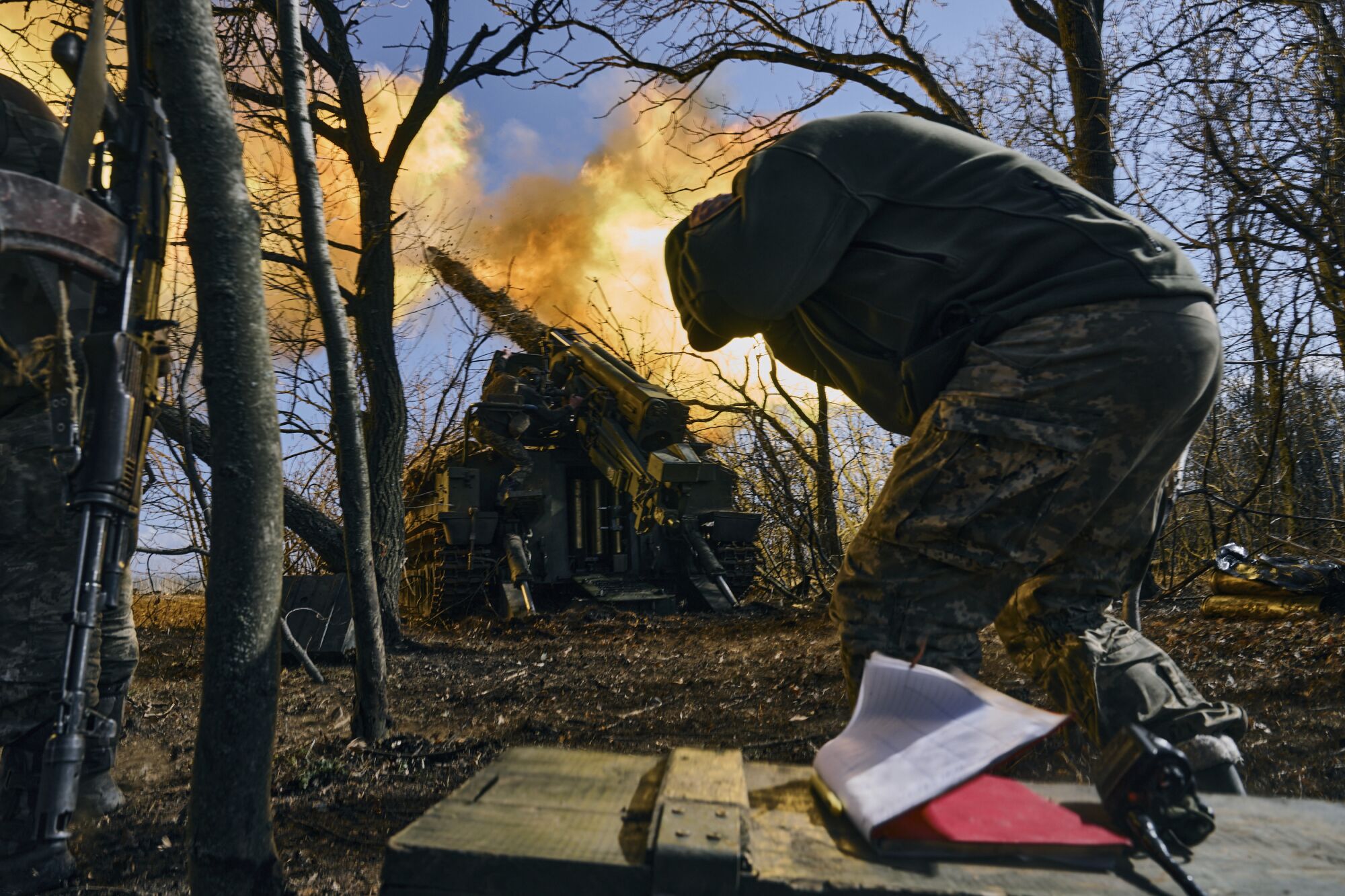 Ukrainian soldiers fire a self-propelled howitzer.