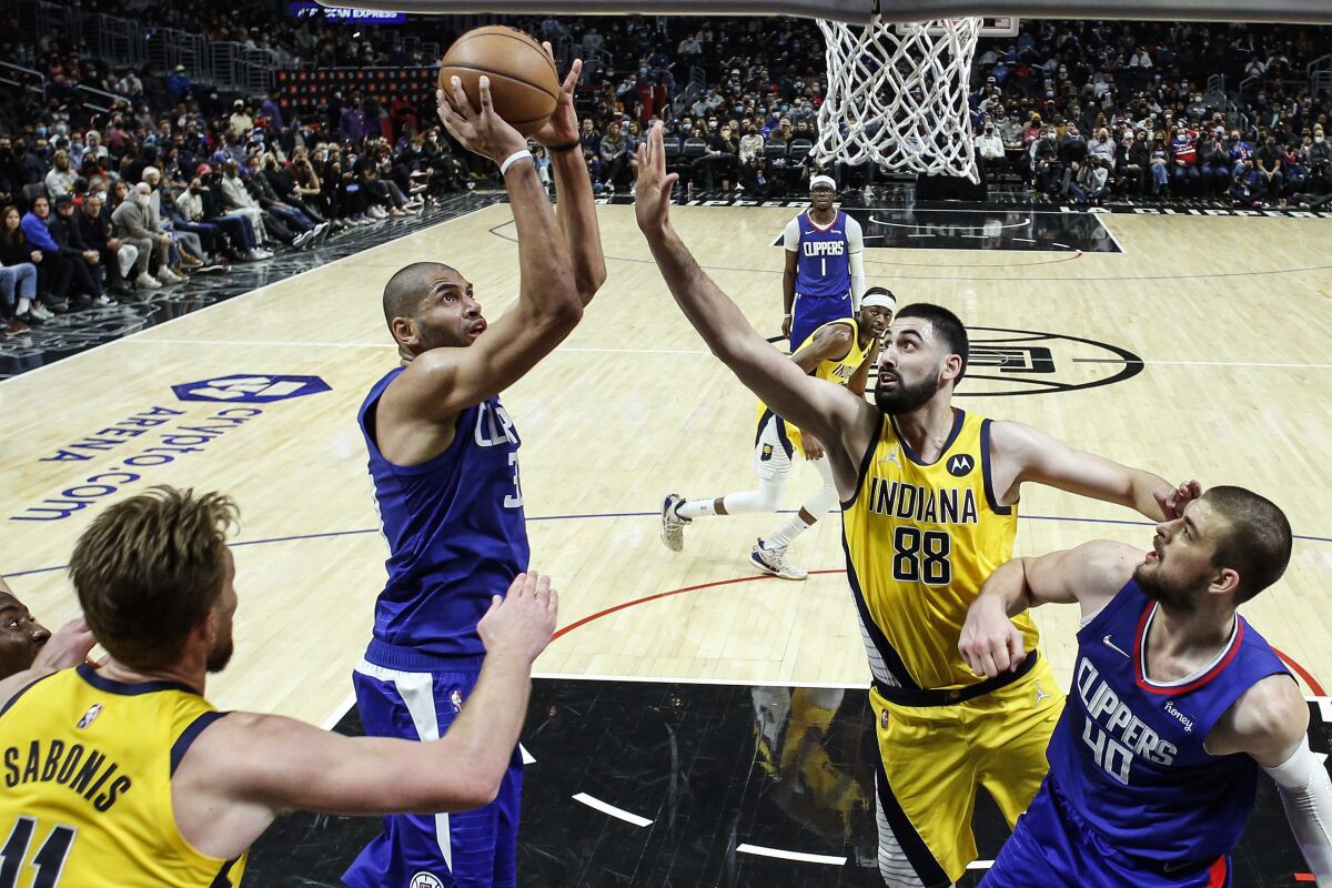 Los Angeles Clippers forward Nicolas Batum, second from left, shoots against Indiana Pacers center Goga Bitadze (88) during the second half of an NBA basketball game in Los Angeles, Monday, Jan. 17, 2022. (AP Photo/Ringo H.W. Chiu)