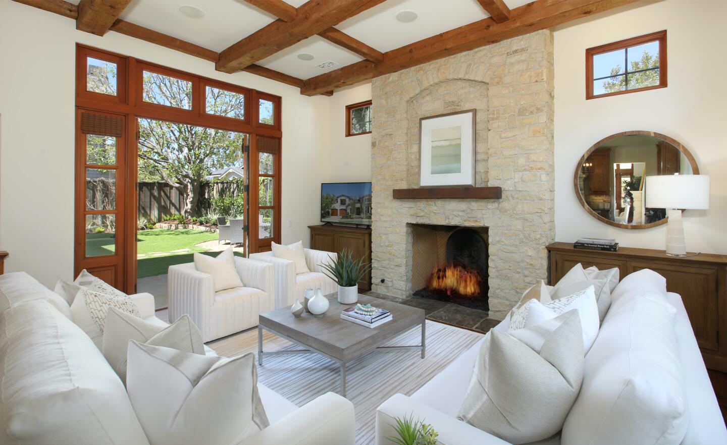 French doors, wood-beam ceilings and a stone fireplace.