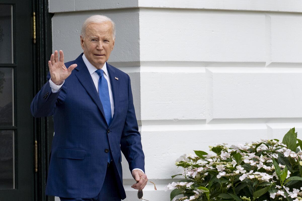El presidente Joe Biden saluda mientras camina hacia el helicóptero Marine One 