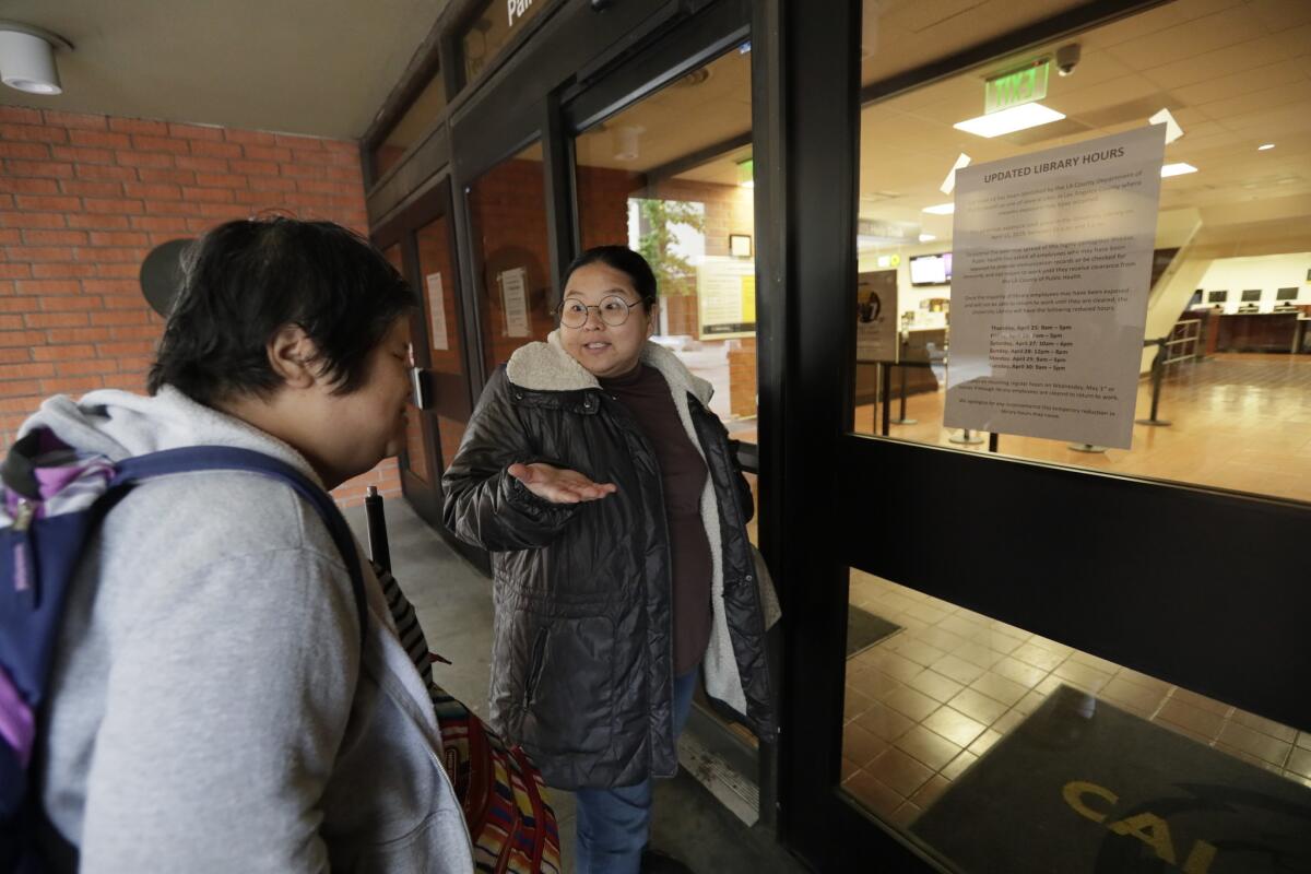 Marie Choi, right, explains to Sophornia Ko that the Cal State L.A. library is closed Friday morning.