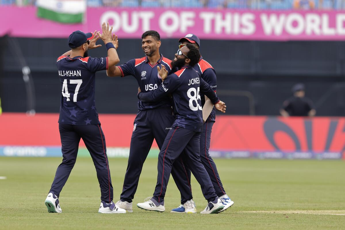 Saurabh Nethralvakar celebrates with U.S. teammates after the dismissal of India's Virat Kohli during a cricket match 