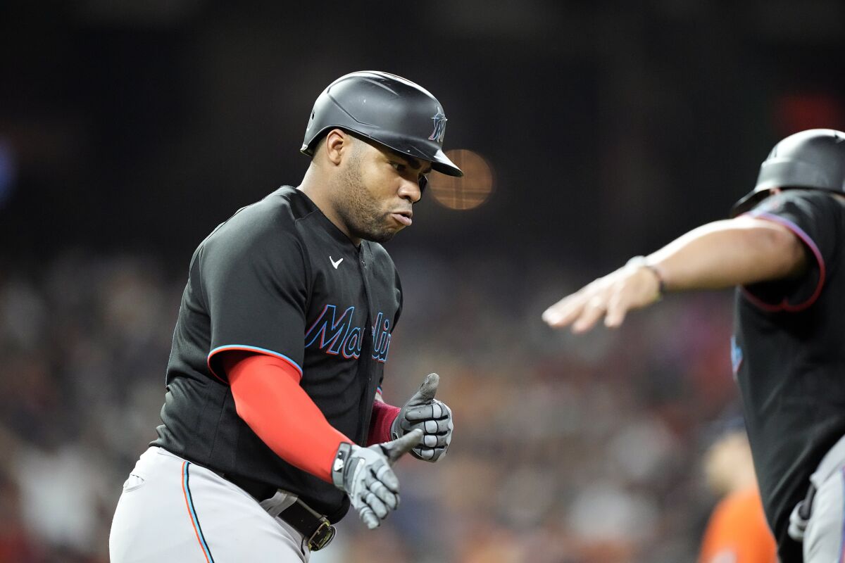 Miami Marlins' Jesus Aguilar, left, celebrates with first base coach Keith Johnson during the fifth inning of a baseball game against the Houston Astros Friday, June 10, 2022, in Houston. (AP Photo/David J. Phillip)