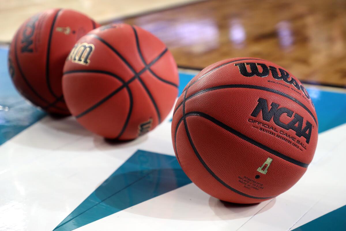 NCAA basketballs sit on the court.