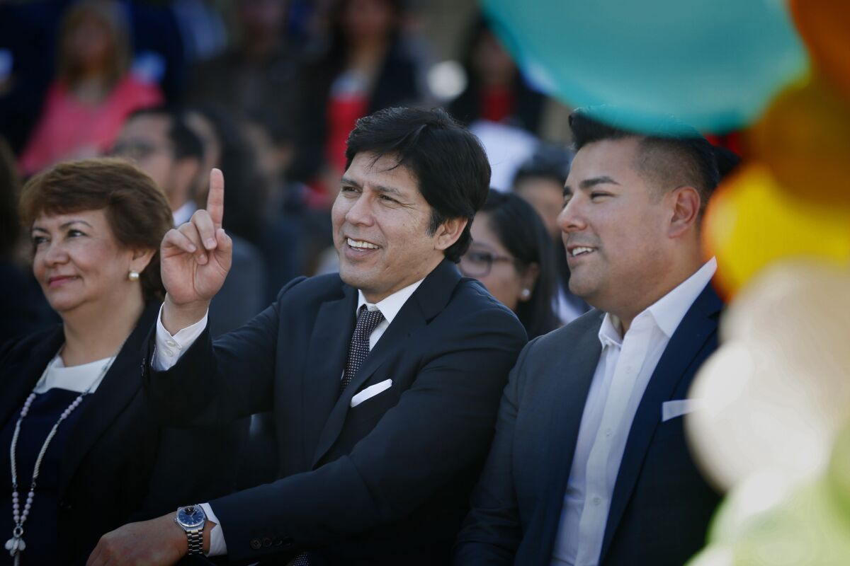 California Senate President Pro Tempore Kevin de León, center, with Sen. Ricardo Lara at a news conference celebrating the expansion of healthcare to children in the country illegally. At left is Arabella Aguirre, a Guatemala-born mother of three undocumented children who will benefit from the signing of the law.