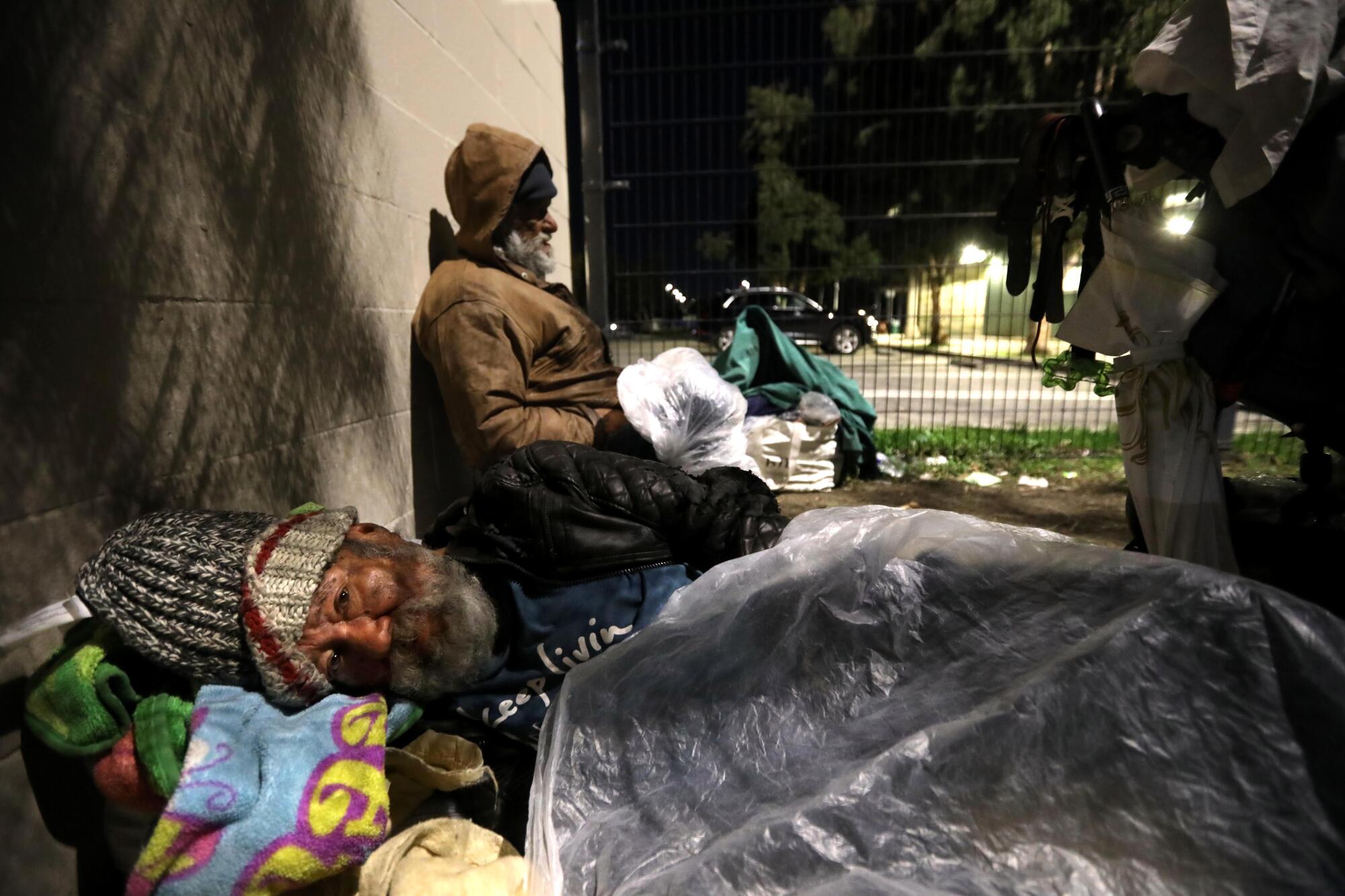 Raul Moreda sleeps under a blanket of plastic at Tiara Street Park in North Hollywood. 