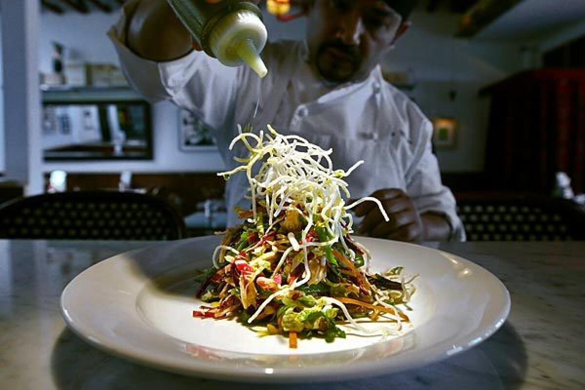 Head chef Ricky Moreno adds a drizzle of olive oil to House Cafe's Chinese chicken salad.