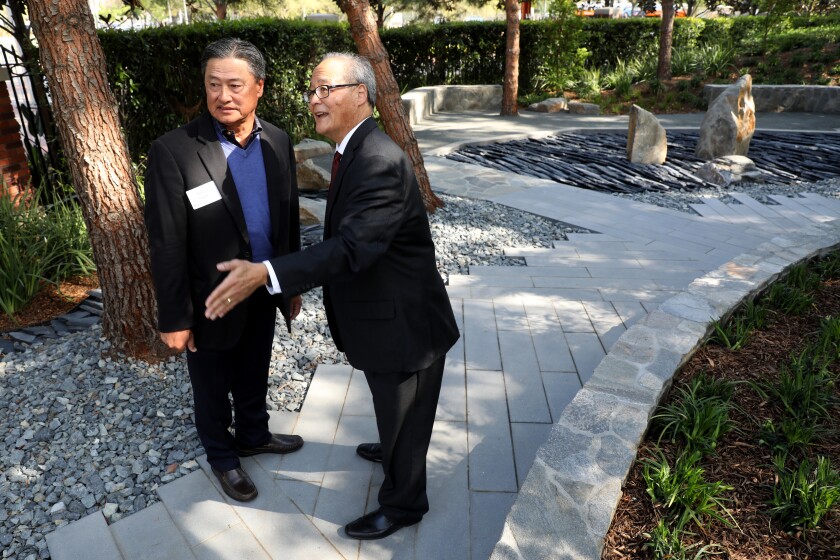 Two men in suits talk