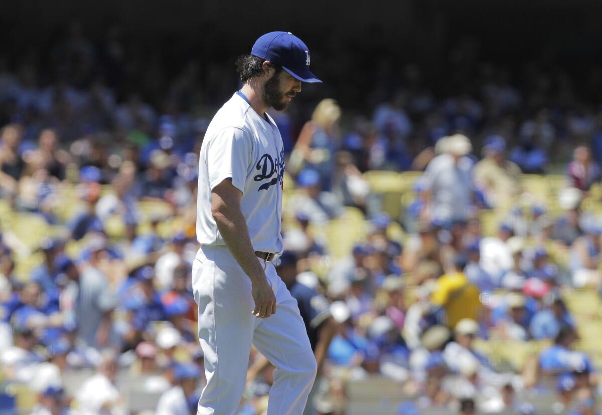 Dan Haren looks down after giving up a three-run double to Brewers catcher Jonathan Lucroy in the second inning of the Dodgers' 7-2 loss to Milwaukee on Sunday at Dodger Stadium.