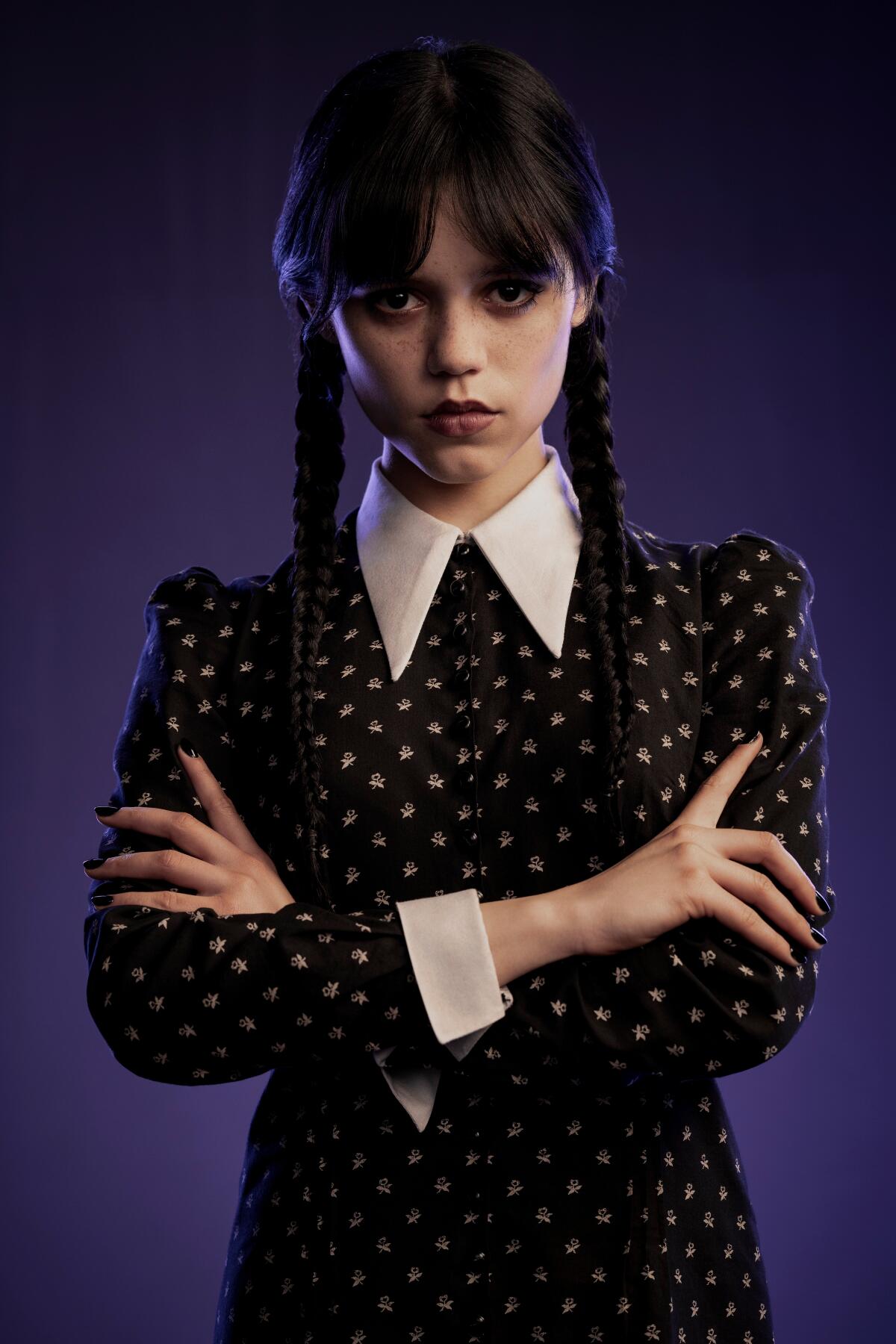Jenna Ortega wears black dress with a deep white collar and cuffs for her Wednesday Addams look.
