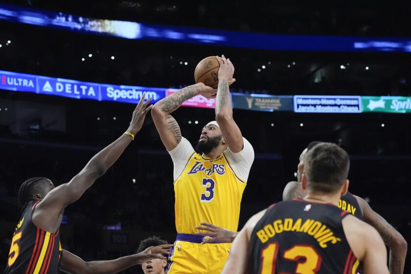 Anthony Davis (3), de los Lakers de Los Ángeles, tira sobre Dejountee Murray (5), de los Hawks de Atlanta, durante la primera mitad del juego de baloncesto de la NBA, el lunes 18 de marzo de 2024, en Los Ángeles. (AP Foto/Damian Dovarganes)