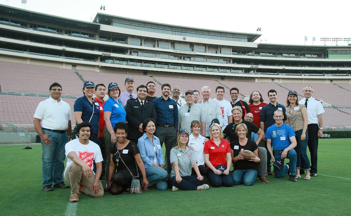 Volunteers and Sleepout participants pose for a group photo on the field of the Rose Bowl for the Salvation Army's Homeless Sleep Out.