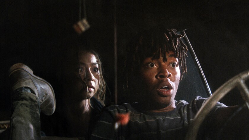 A frightened young man and woman in a car at night in the movie "First Date."