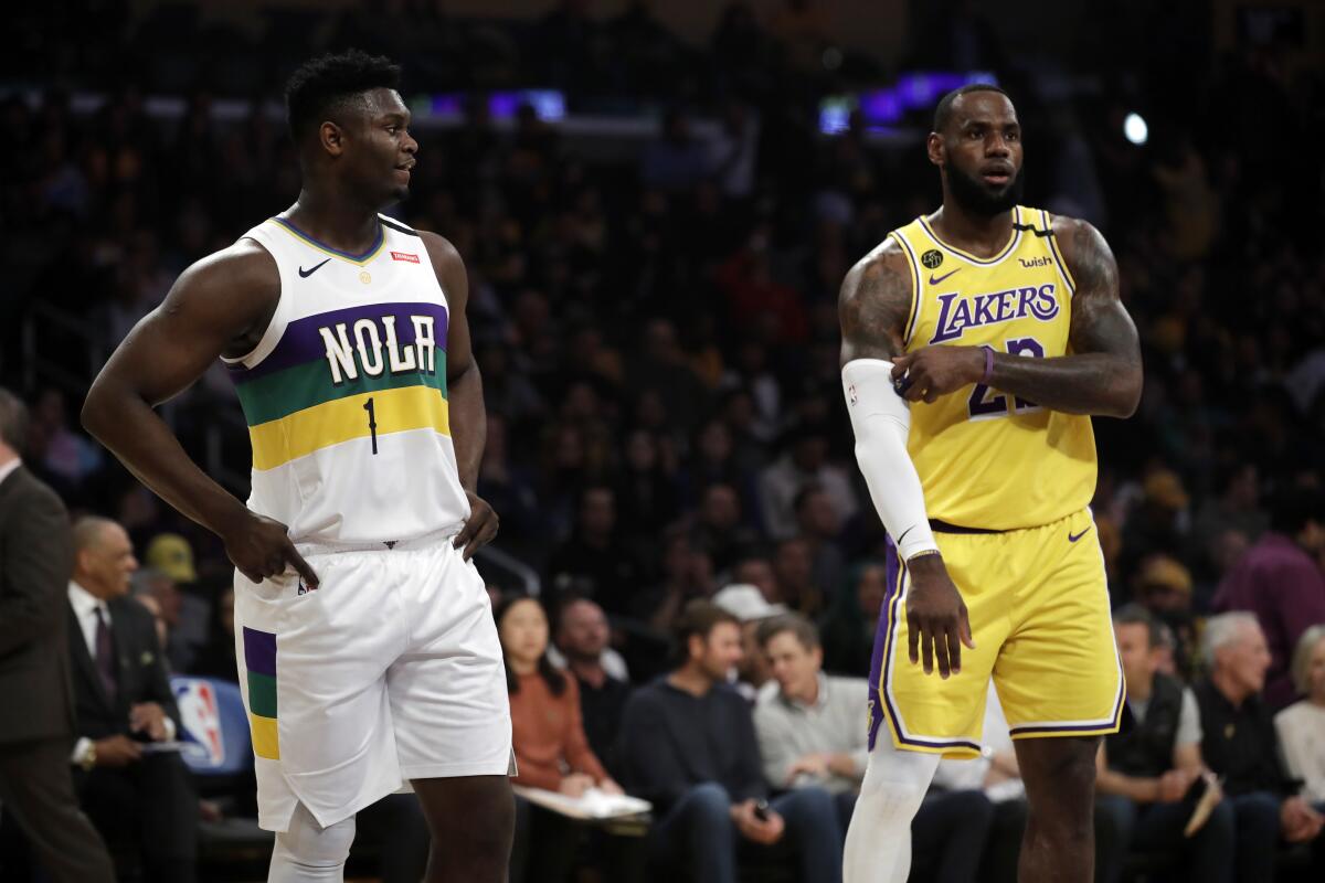 New Orleans Pelicans rookie Zion Williamson, left, stands next to Lakers star LeBron James during their first game as opponents.