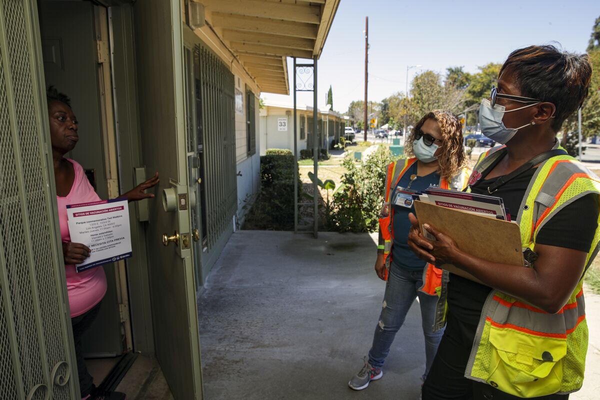 Linda Hawkins, left, who is vaccinated, collects the information about COVID-19 vaccine for her family