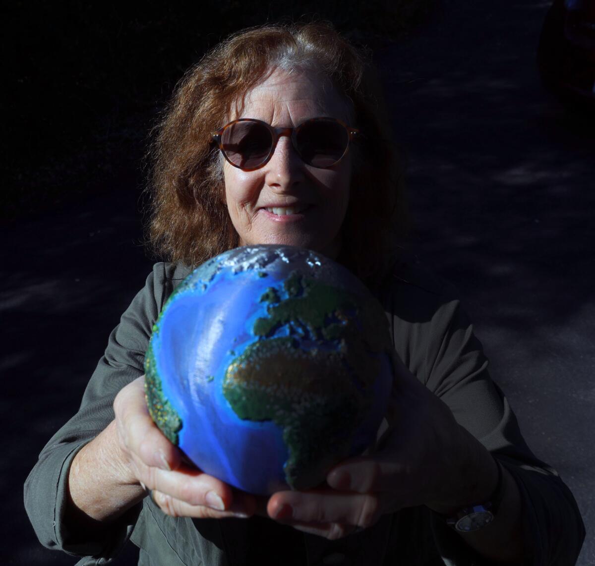 Environmental artist Ronnie Siegel, creator of the project Carry the Earth, holding Earth 1, "Ecosystems," at her home in La Cañada Flintridge.