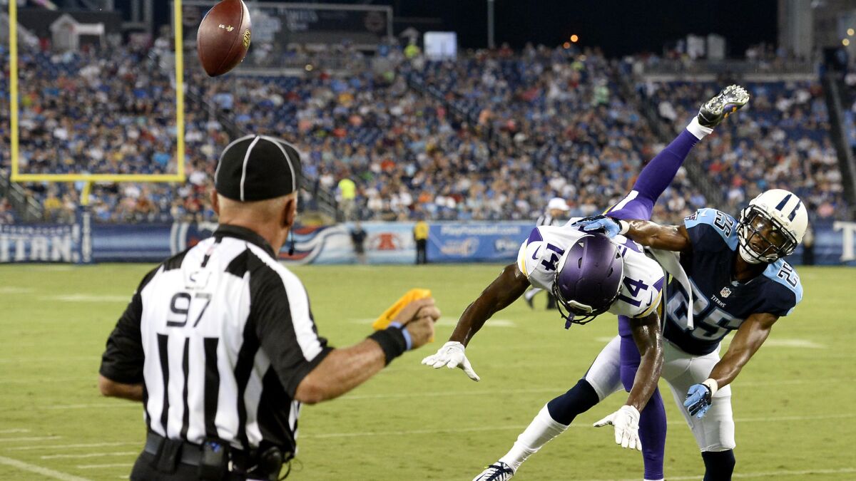 Side judge Tom Hill, left, throws a penalty flag as Titans cornerback Blidi Wreh-Wilson (25) breaks up a pass intended for Vikings wide receiver Stefon Diggs (14) in a preseason game on Sept. 3.