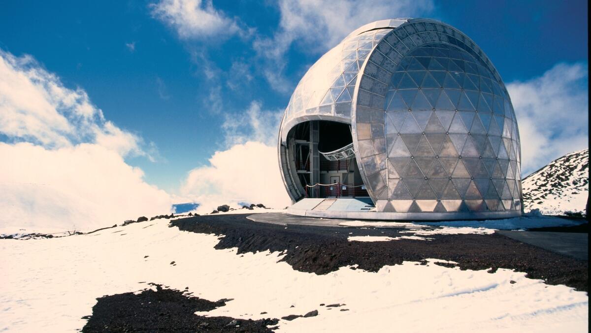 An observatory is perched on snow-covered ground atop Mauna Kea on Hawaii Island.