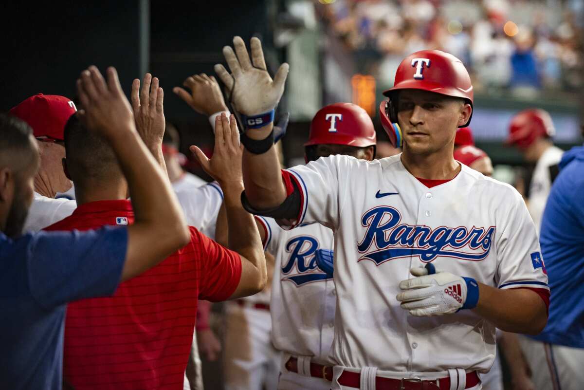 Texas Rangers' Corey Seager is congratulated by teammates after driving in a run against the Houston Astros on July 3, 2023.