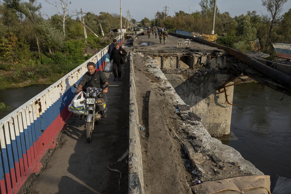 A man drives by motorbike on a destroyed bridge.