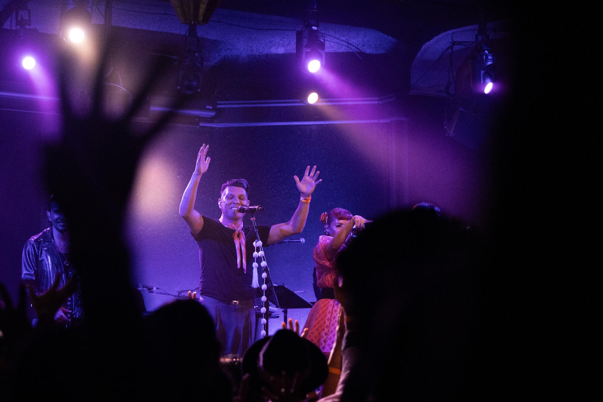 An artist raises his hand during a show.